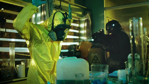 Fully Armed Special Anti-Narcotics Task Forces Soldier Arrests Clandestine Chemist in the Drug Producing Underground Laboratory. Chemist Raises Hands and Surrenders. A lot of Functional Drug Production Equipment is Standing Around. Shot in Slow Motio - Photo, Image