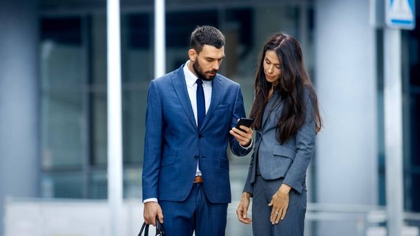 Business Woman and Business Man Use Smartphone and Talk on the Busy Big City Street. Both Look Exquisitely Stylish. - Zdjęcie, obraz