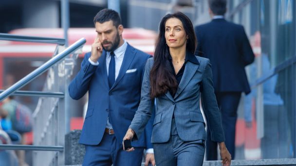 Male and Female Business People Walking Down the Street in the Business District. - Fotoğraf, Görsel