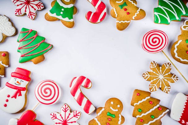 Varias galletas tradicionales de pan de jengibre de Navidad glaseadas con azúcar coloridas, sobre fondo blanco ver espacio de copia - Foto, Imagen
