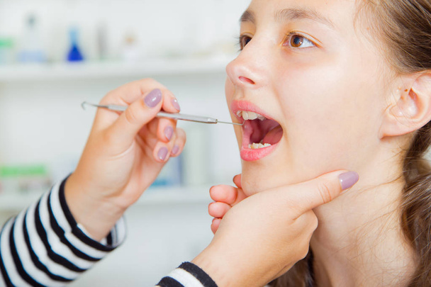 Close-up of little girl opening his mouth wide during treating... - Foto, Bild