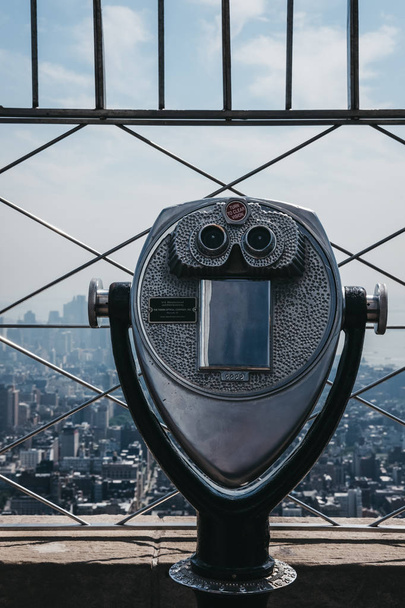 New York, USA - May 29, 2018: Coin operated binoculars on the observation platform at Empire State Building, New York, USA, city on the background. It is one of the most visited attractions in NYC. - Fotoğraf, Görsel