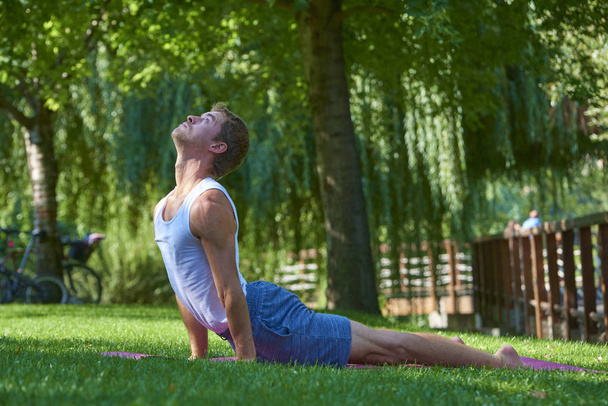 Full length shot of man doing yoga outdoor.  - 写真・画像