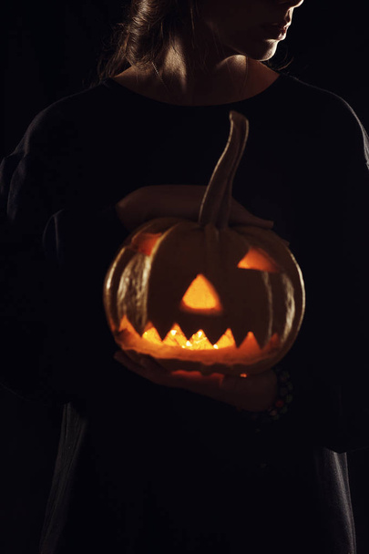 Woman silhouette with a pumpkin on black ba - Foto, Imagen