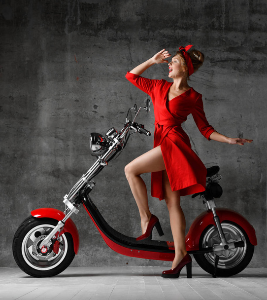 Woman ride sit on motorcycle bicycle scooter pinup retro style laughing smiling red dress - Photo, image