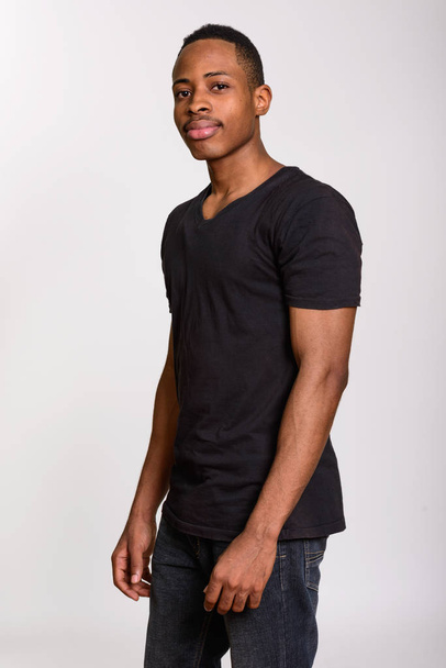Fiatal csinos afrikai férfi állandó fehér háttér - Fotó, kép