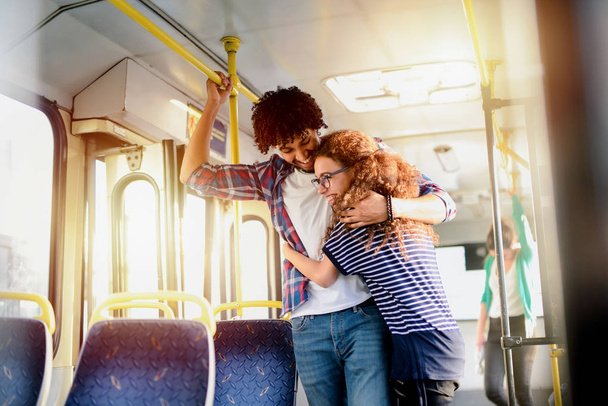 Linda pareja joven abrazándose en un transporte público. Divertirse y viajar juntos
. - Foto, imagen