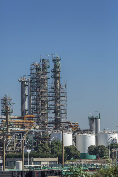 Teollisuuden teema, yksityiskohtainen osa näkymä, öljynjalostamon teollisuuskompleksi rakennuksineen, laitteineen ja koneineen, sinisen taivaan tausta, Portugalissa
 - Valokuva, kuva