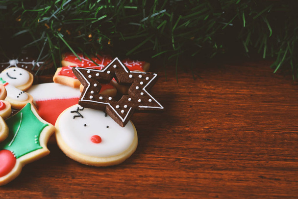 Close up view of colorful Christmas cookies with festive decoration on wooden table. xmas holiday concept. - Φωτογραφία, εικόνα
