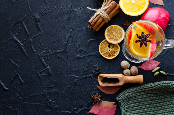 Autumn mulled wine based on white wine with orange, apple and spices cinnamon sticks, star anise, nutmeg, cardamom and clove on black background. Seasonal beverages recipe. Top view. Copy space. - 写真・画像