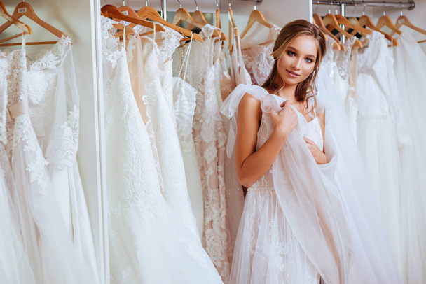 Female trying on wedding dress in a shop - Zdjęcie, obraz