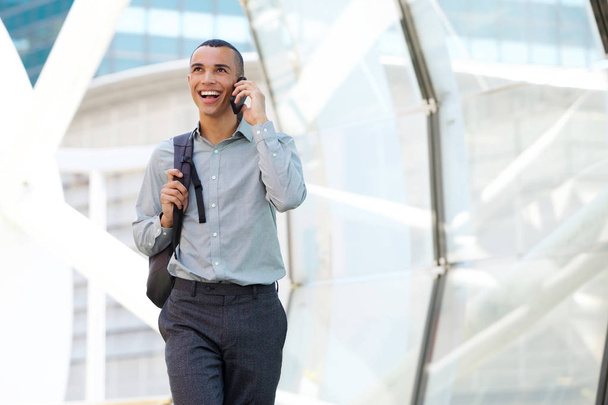 Retrato de homem de negócios feliz andando e conversando com celular
 - Foto, Imagem
