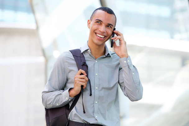 Πορτρέτο του νεαρός επιχειρηματίας, μιλώντας στο κινητό τηλέφωνο και χαμογελαστός - Φωτογραφία, εικόνα