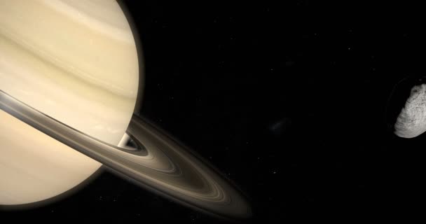 Janus księżyc na orbicie wokół planety Saturn w przestrzeni kosmicznej - Materiał filmowy, wideo
