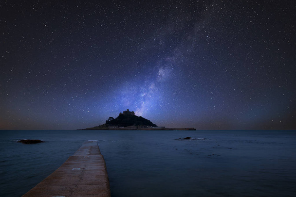 Impressionante vibrante Via Láctea imagem composta sobre a paisagem de St Michaels Mount Bay na maré alta
 - Foto, Imagem
