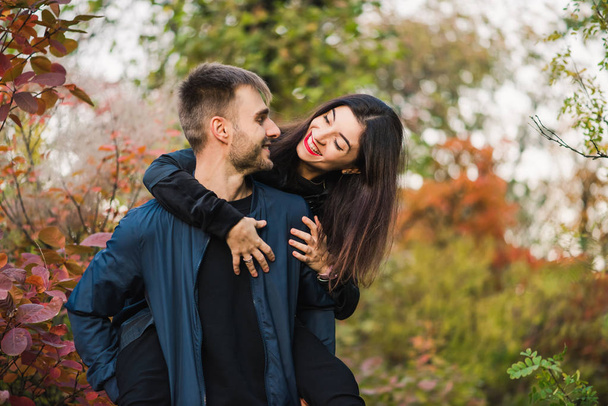 秋の森の中を歩く幸せな若いカップル - 写真・画像