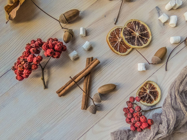 autumn still life with Rowan, marshmallows, pine and cones, lemon, leaves, on white wooden background top view. object group - 写真・画像