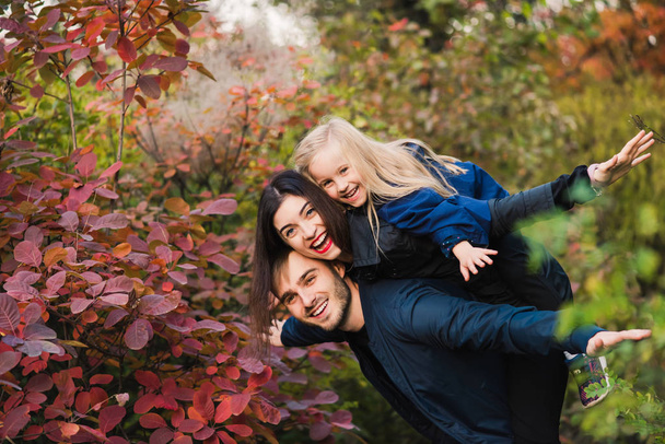 Gelukkig jonge familie glimlach in herfst park - Foto, afbeelding