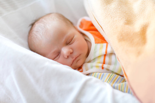 Nettes entzückendes Neugeborenes, das friedlich im Bett schläft. Neugeborenes Kind, kleines Mädchen im Bett liegend. Familie, neues Leben, Kindheit, neues Konzept - Foto, Bild