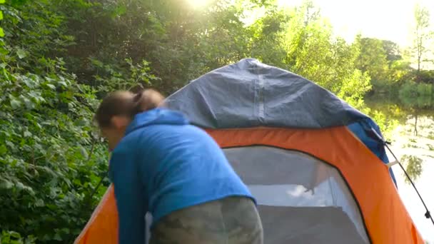 Femme met une tente touristique sur la rive de la rivière
 - Séquence, vidéo