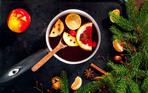 Christmas background. Hot mulled wine with ingredients in authentic ladle on on vintage rusty metal background. The concept of celebration and cooking warming drinks. Top view, close up, copy space - Photo, Image