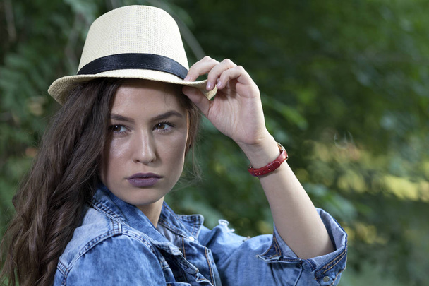 Portrait of young beautiful woman with hat in nature - Фото, изображение