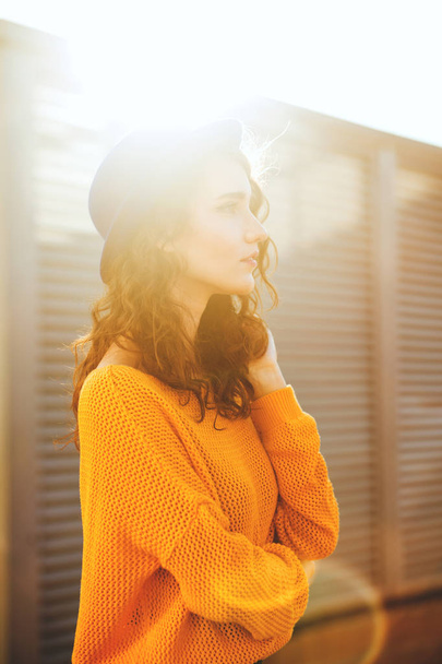 Sunny portrait of trendy dressed romantic woman wearing blue hat and yellow sweater enjoying warm autumn evening - Foto, immagini