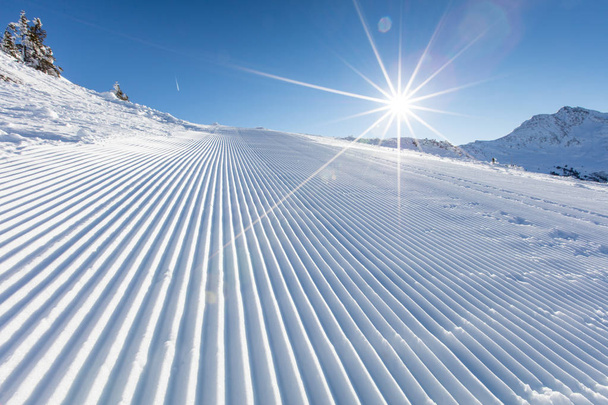 Nieve fresca en la pista de esquí durante el día soleado
. - Foto, imagen