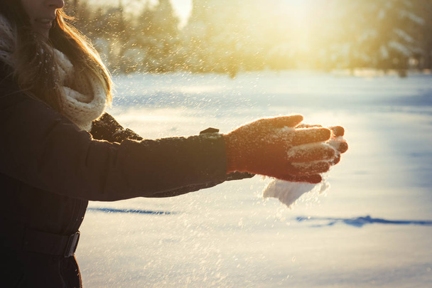 Female hands in red gloves clap their hands with snow. Winter Concept. - Photo, Image