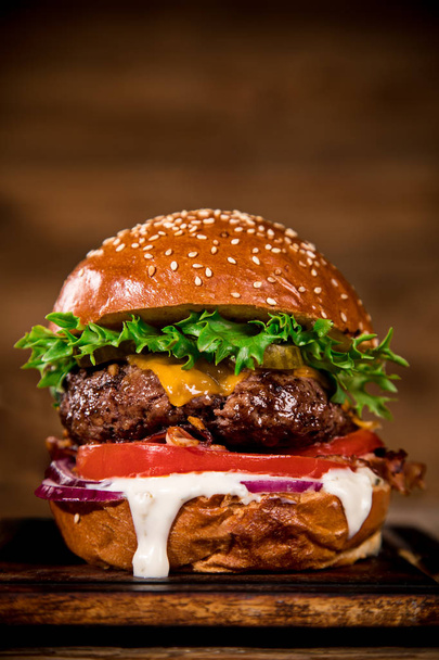 Close-up of home made tasty burger on wooden table. - 写真・画像