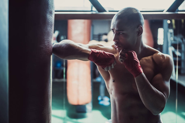 Afro americký boxer, jeho ruce zabalené v červené obvaz, je trénink v tělocvičně - Fotografie, Obrázek