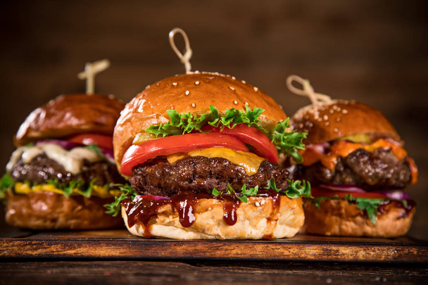 Close-up of home made tasty burgers on wooden table. - Φωτογραφία, εικόνα