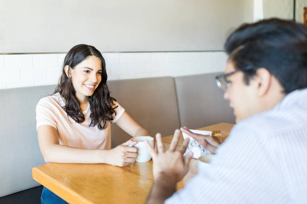 Усміхнена жінка, що показує інтерес до чоловіка під час побачення з кавою в кафе
 - Фото, зображення