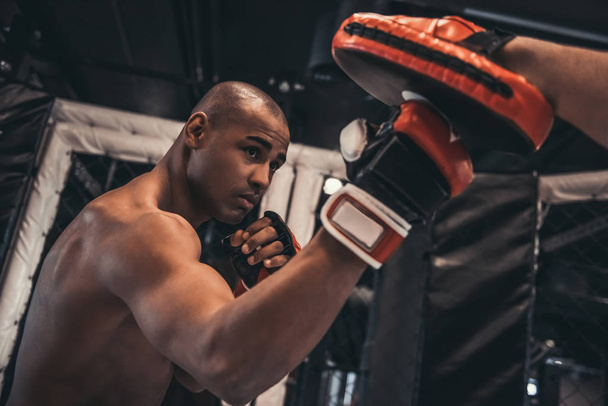 Afro boxeur américain en gants s'entraîne avec un entraîneur dans le ring de boxe
 - Photo, image