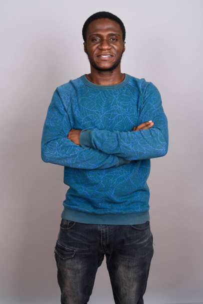 Giovane uomo africano che indossa camicia blu a maniche lunghe contro grigio b
 - Foto, immagini