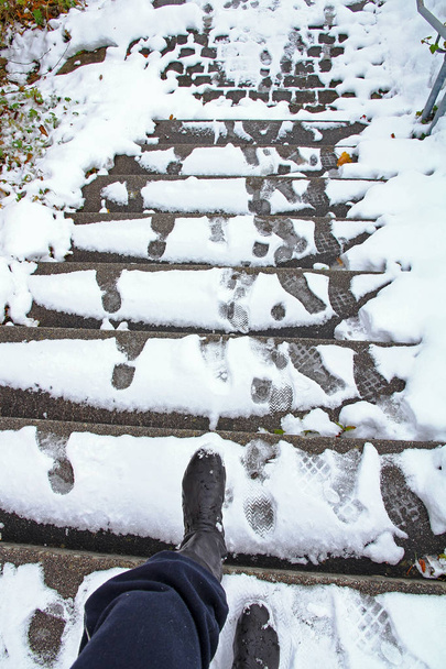 Kış aylarında karla kaplı bir merdiven üzerinde kayma bir tehlike var. Bir kadın bir kaygan merdiven gitmek istiyor - Fotoğraf, Görsel