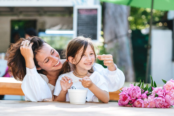 Mother and daughter are sitting in a cafe - Photo, Image