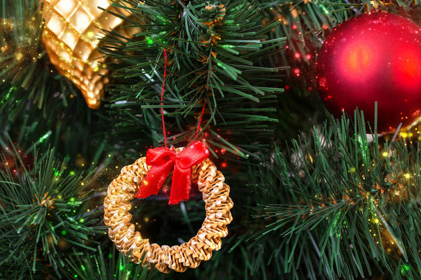 Gold, red and straw vintage decorations in the Scandinavian style on an artificial Christmas tree, close-up - Foto, immagini