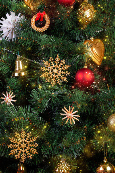 Goud, rood en stro vintage decoraties in de Scandinavische stijl op een kunstmatige kerstboom, close-up - Foto, afbeelding