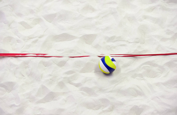 Buntes Volleyball und rote Linie auf dem Sand. - Foto, Bild