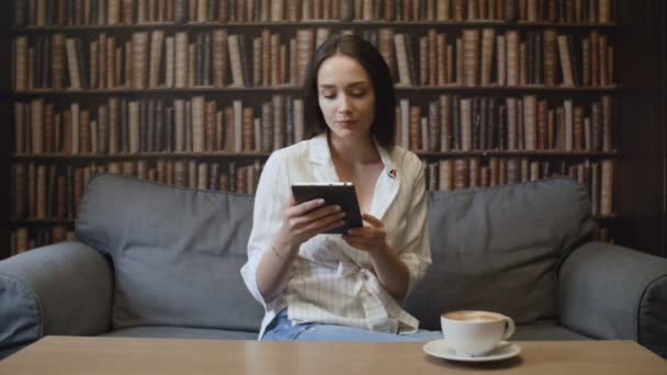 Mulher bonita bebendo café e lendo livros no café
 - Filmagem, Vídeo