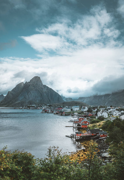 Landscape of fishing village Reine with the Reine Fjord during sunset with nice lights on mountain, blue sky and clouds. Lofoten, Norway - 写真・画像