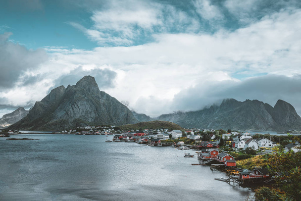 Landscape of fishing village Reine with the Reine Fjord during sunset with nice lights on mountain, blue sky and clouds. Lofoten, Norway - Fotoğraf, Görsel