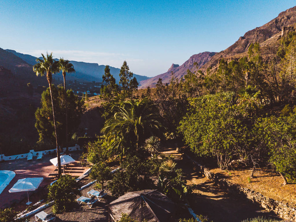 Avida hotel, Gran Canaria, Spain, July 5, 2018. Aerial view on the pool at the resort by the bar and palms located in the mountains. - Photo, Image