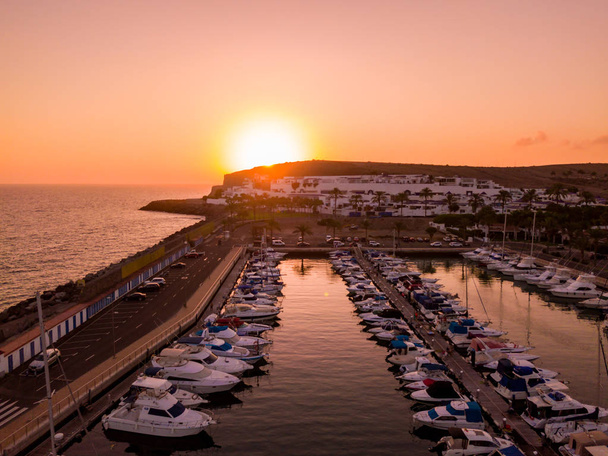 Beautiful aerial sunset view over the docks with many luxury yachts docked by the pier. - Fotó, kép