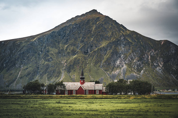 Flakstad Church with mountains in the background, exquisite XVIII century baroque masterpiece in the Arctic, Flakstadoy, Lofoten Islands, North of the Arctic Circle, Norway - Photo, image