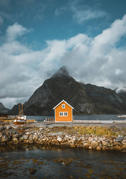 Yellow rorbu houses of Sakrisoy fishing village on a cloudy day with mountains in the background. Lofoten islands, Norway - Foto, immagini