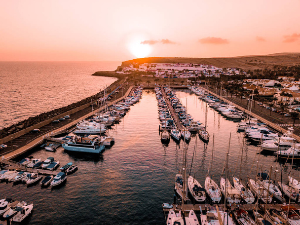 Beautiful aerial sunset view over the docks with many luxury yachts docked by the pier. - Fotoğraf, Görsel