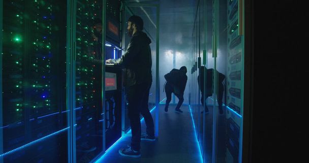 Dois hackers terminando de atacar e escapar de um data center smokey
 - Foto, Imagem