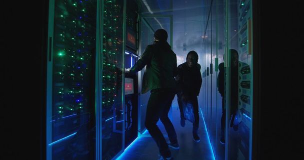 Two hackers finishing attack and escaping a smokey data center - Fotó, kép